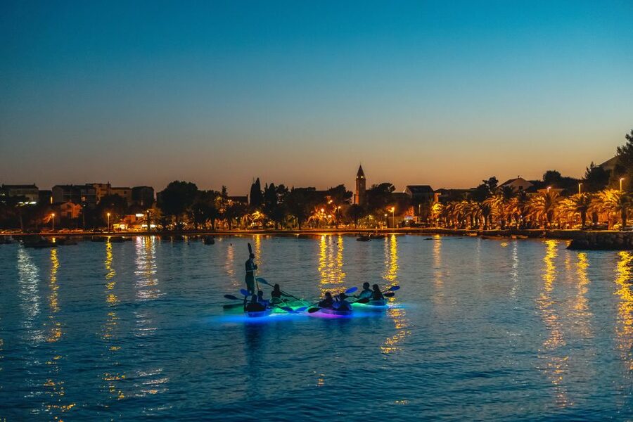 Split: Illuminated Evening Guided Kayaking Tour - Sea return and Split from offshore: cliffs, white rocks, and starry calm